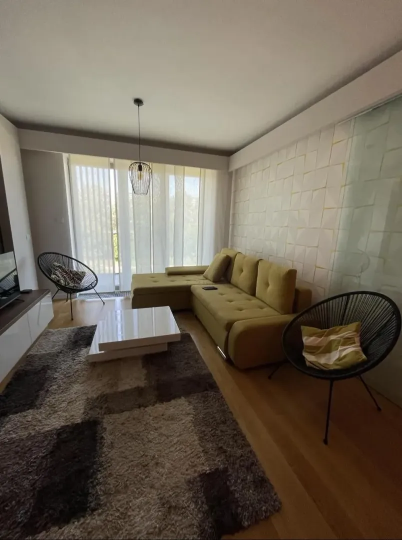 Living room with a sectional sofa, coffee table, and armchairs.