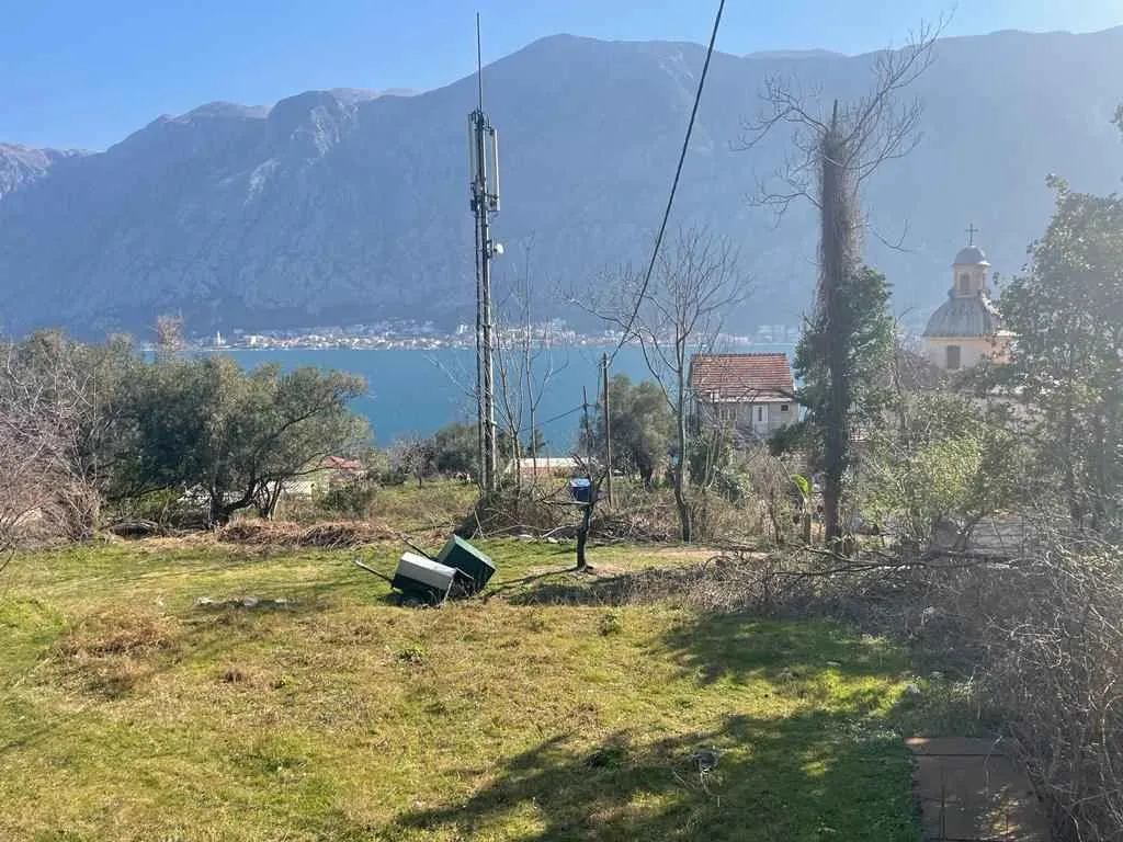 Travnati plac sa krasnim pogledom na more i planine u daljini.