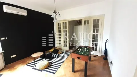 Living room with a black accent wall and a foosball table. - image 10