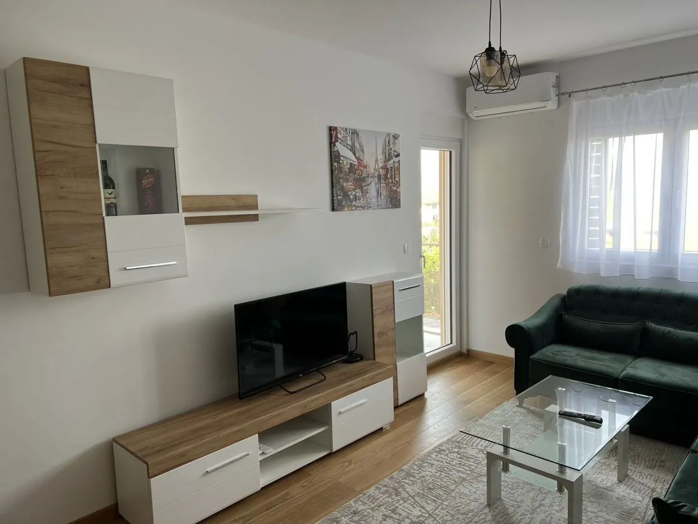Bright living room with modern furniture and a television.