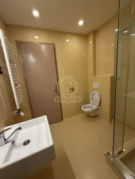 Savremeno opremljeno kupatilo sa tuš kabinom, umivaonikom i toaletom u bež tonovima. - image 12