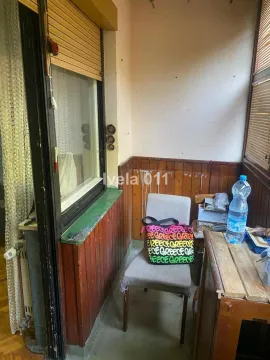 Zastakljeni balkon sa stolicom i drvenom oblogom na zidu. - image 4