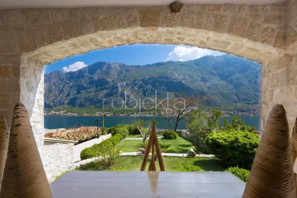 View of the sea and mountains from a covered stone terrace.