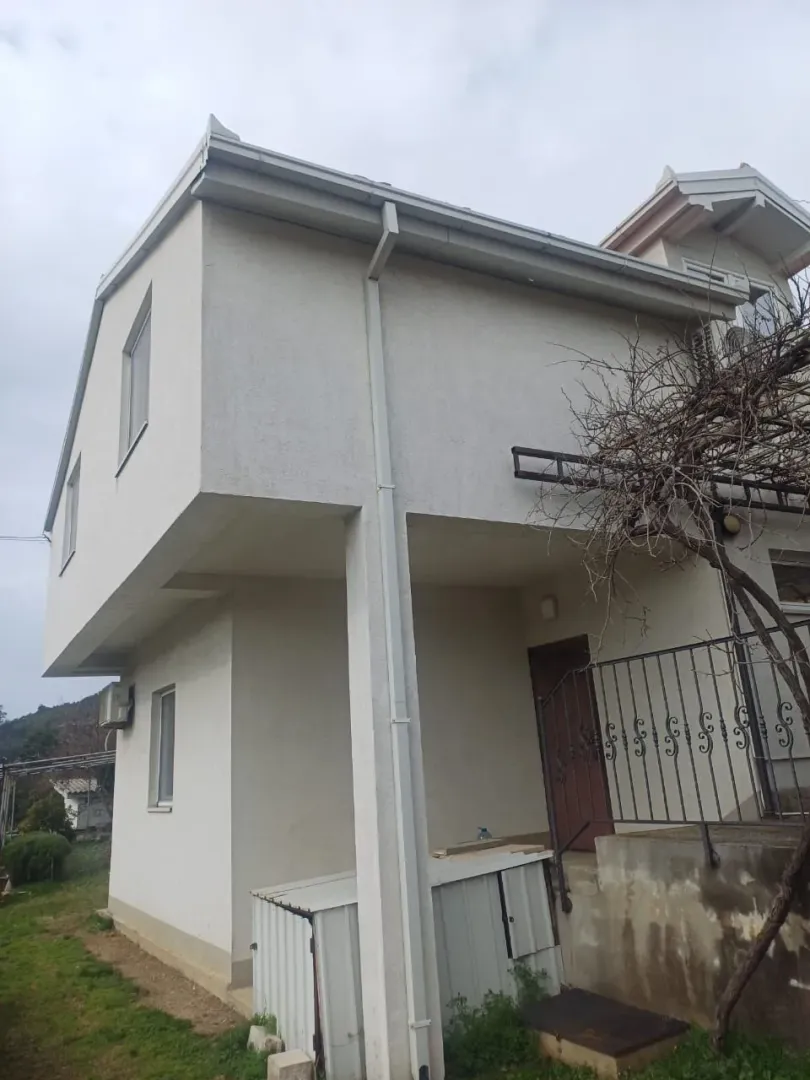 Spoljašnji izgled dvospratne kuće sa fasadom i ulaznim stepeništem.