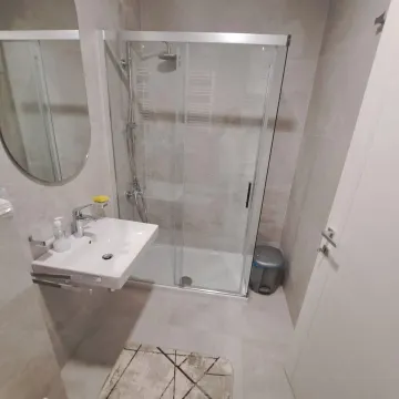 Smaller bathroom with a shower cabin, washbasin, and mirror. - image 6