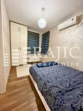 Smaller bedroom with a bed, wardrobe, and air conditioning unit. - image 8