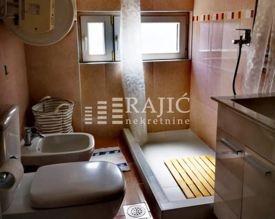Smaller bathroom with a shower cabin, sink and sanitary facilities.