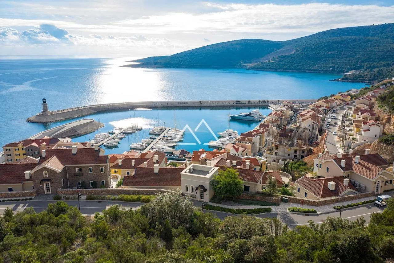 Pogled iz ptičje perspektive na marinu, obalu i naselje.