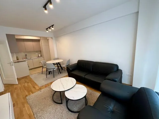 Living room with a sofa set and dining area in an open plan space.