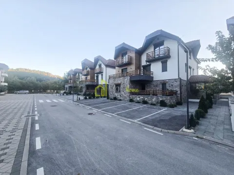 Pogled na spoljašnjost zgrade sa parkingom i uređenim dvorištem. - image 2