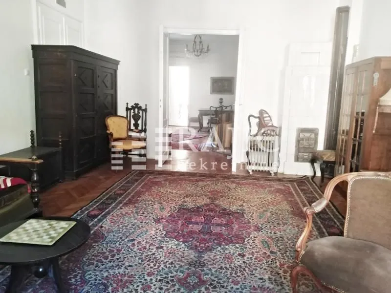 Living room with antique furniture and a rug.