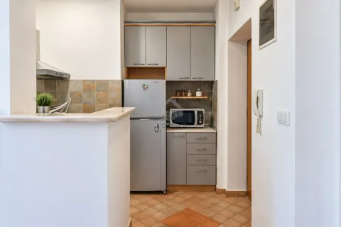 Smaller kitchen with grey cabinets and a refrigerator. - image 4