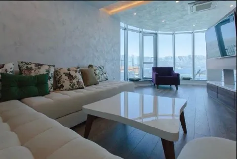 Spacious living room with a sofa, coffee table and large glass windows overlooking the sea. - image 4