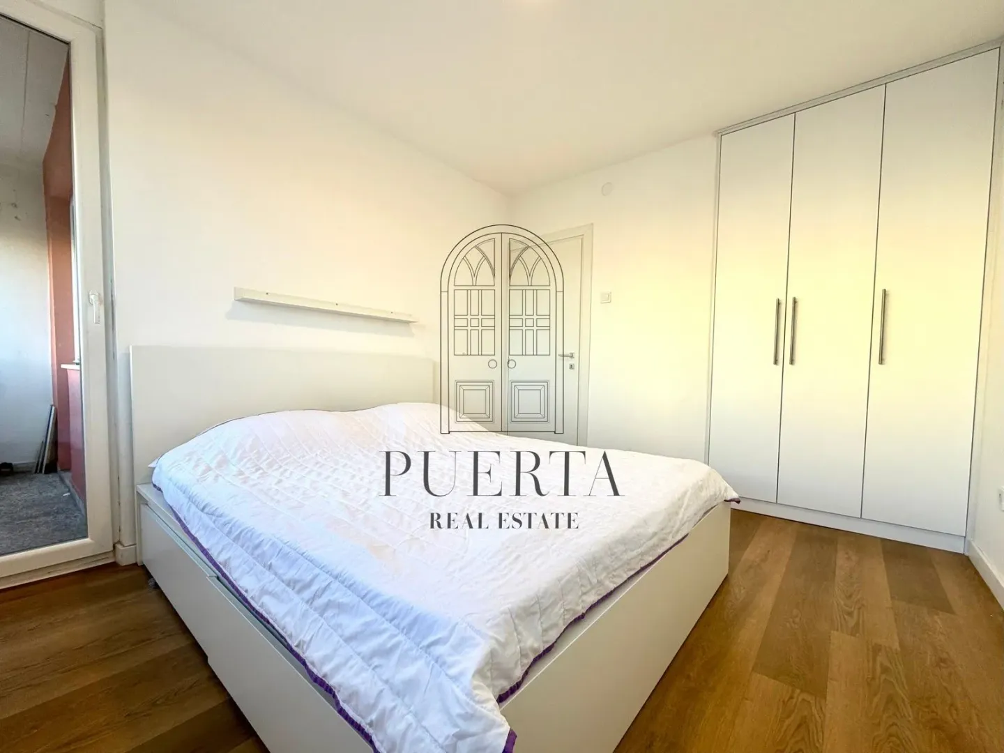 Bright bedroom with a double bed and a built-in wardrobe.