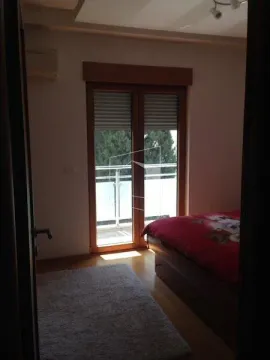 View from the doorway into a bedroom with a bed and balcony doors. - image 13