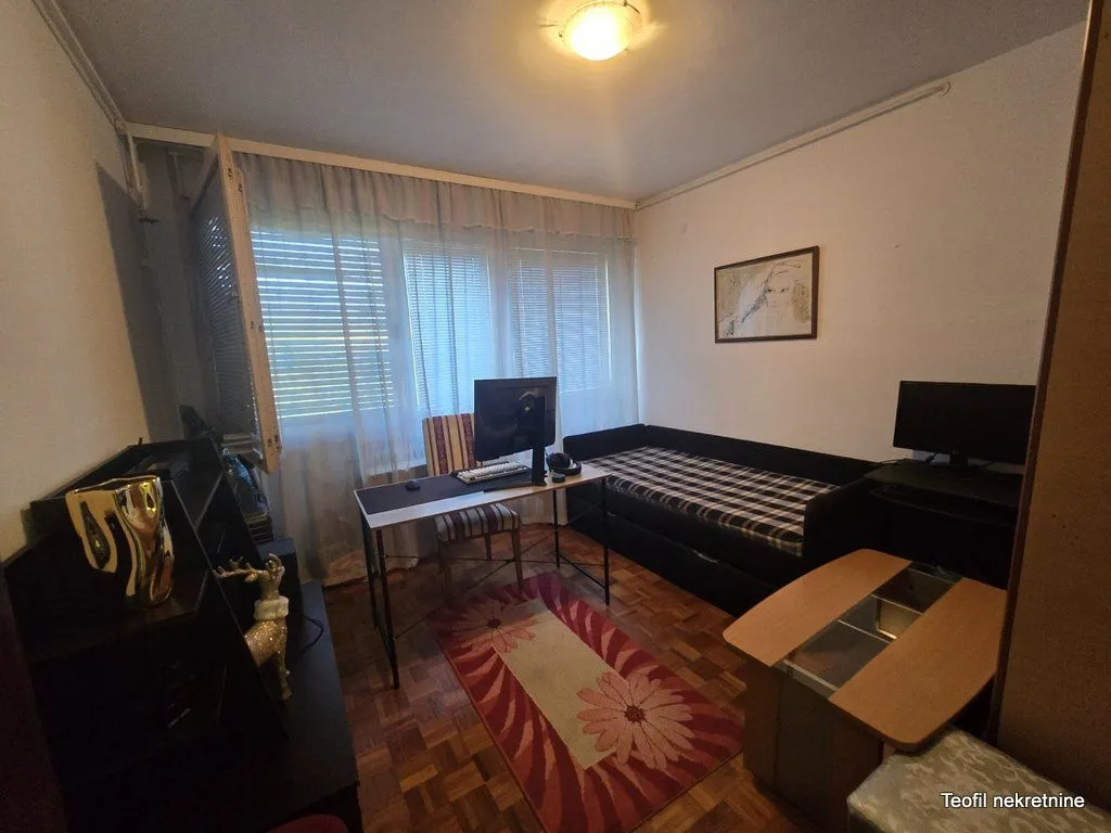 Nameštena spavaća soba sa krevetom i radnim stolom.