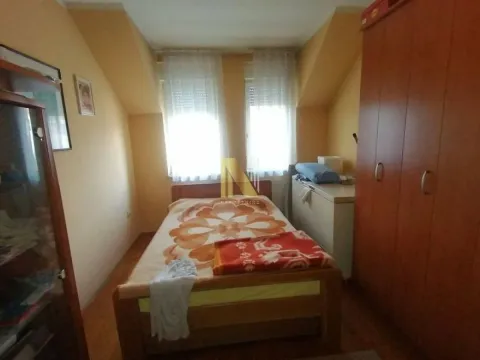 Nameštena spavaća soba sa krevetom i ormanom ispod krovnih kosina. - image 7
