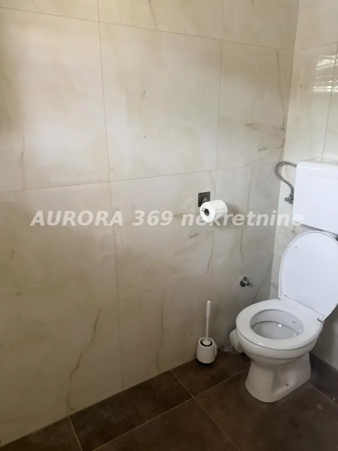 Pogled na kupatilo sa keramičkim pločicama i wc šoljom.