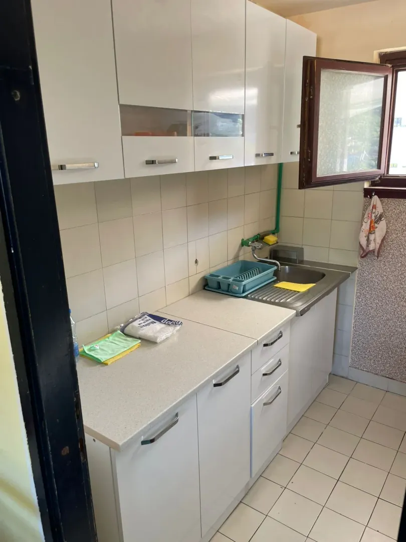 Small kitchen with white cabinets and a sink.