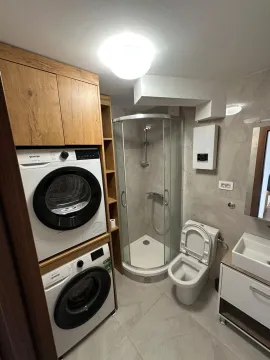 Kupatilo sa tuš kabinom, WC šoljom, umivaonikom i ugrađenom mašinom za pranje i sušenje veša. - image 12