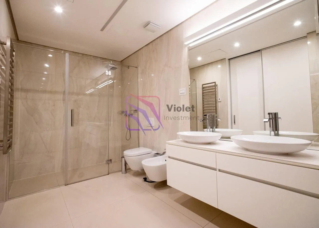 Moderne kupatilo sa tuš kabinom, dva umivaonika i WC šoljom.