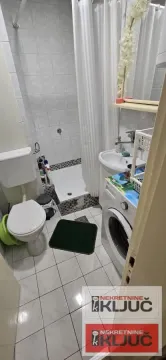 Pogled na manje kupatilo sa tuš kabinom, umivaonikom i veš mašinom. - image 5