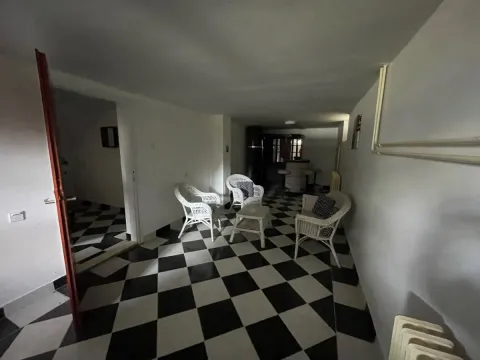 Dnevna soba sa garniturom za sedenje i crno-belim keramičkim pločicama na podu. - image 35