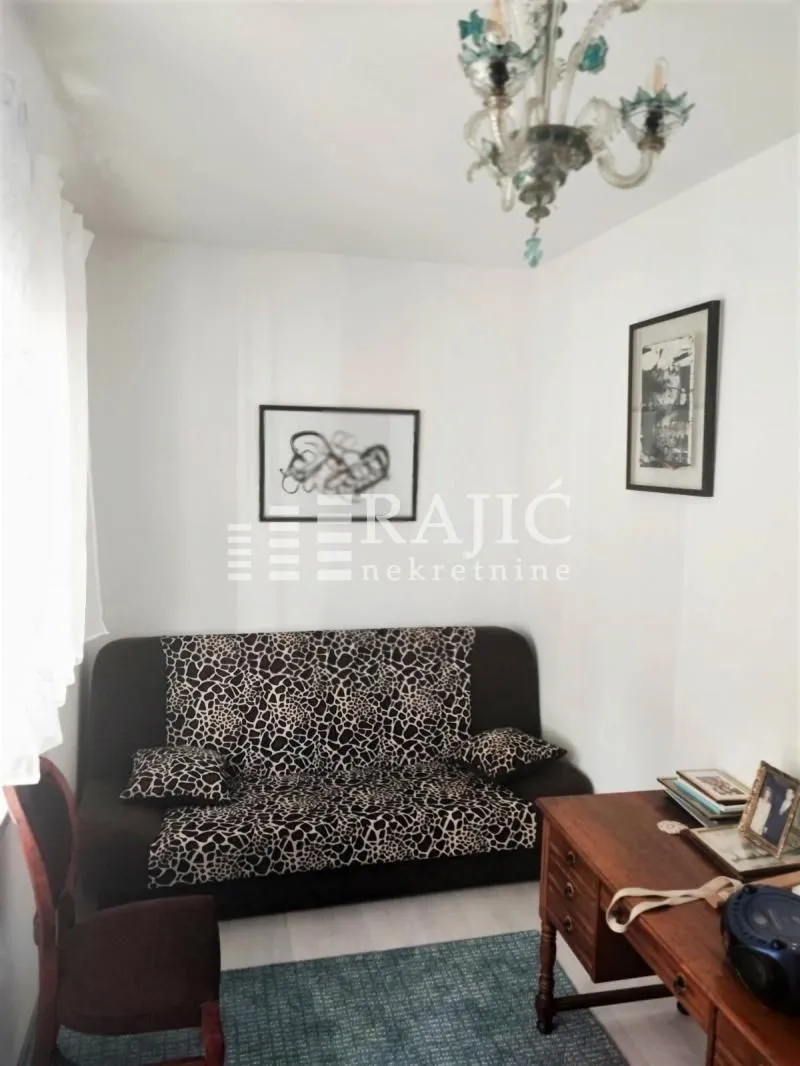 Living room with a sofa, desk, and pictures on the wall.
