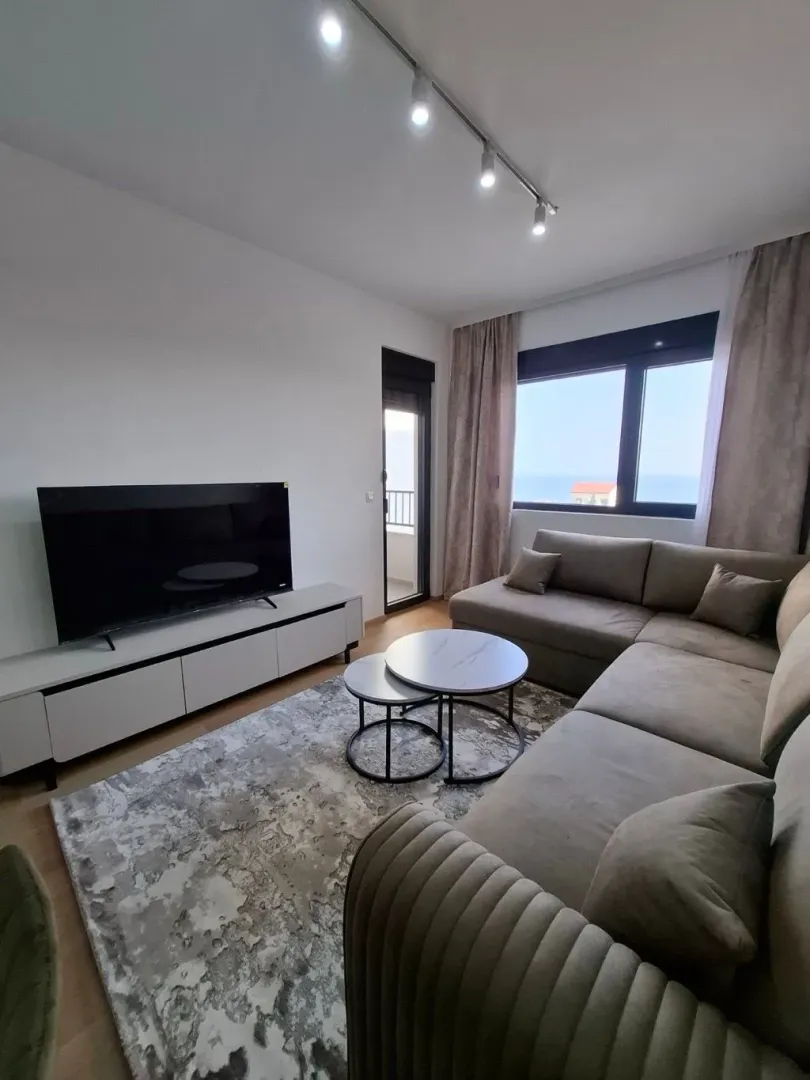 Living room with a sectional sofa, TV, and access to the terrace.