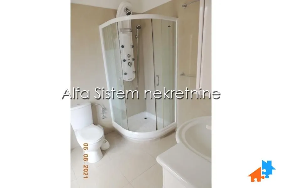 Bathroom equipped with a shower cabin, washbasin, and toilet.