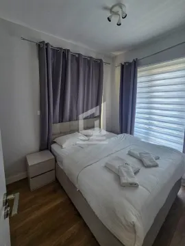 Namještena spavaća soba sa bračnim krevetom, noćnim stočićem i prozorom sa zavjesama. - image 6