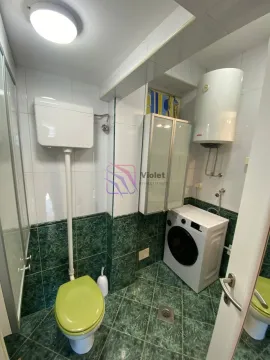 Manje kupatilo sa zelenim pločicama, wc šoljom, mašinom za veš i bojlerom. - image 15