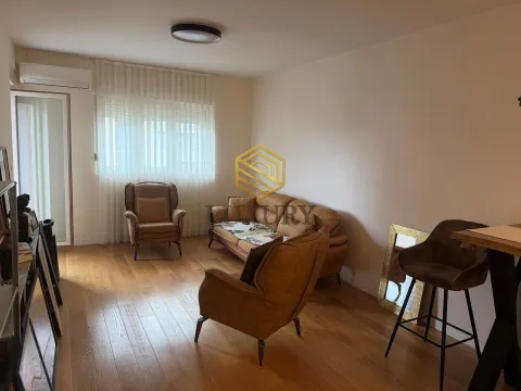 Prostrana dnevna soba sa garniturom za sedenje i drvenim podom. - image 3