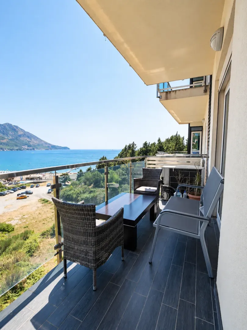 Namješten balkon sa garniturom za sjedenje i pogledom na more.