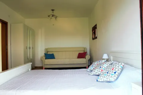 Furnished bedroom with a double bed, wardrobe, and a sofa. - image 6