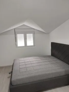 Bright attic bedroom featuring a modern grey bed. - image 8
