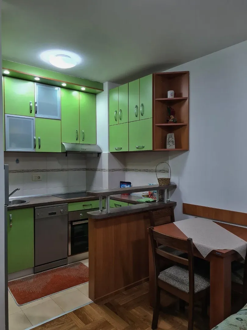 Kitchen with green cabinets and a small dining table.