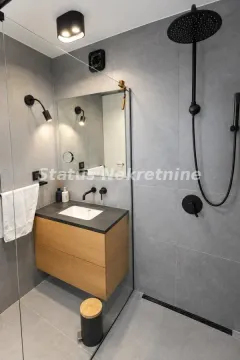 Moderno opremljeno kupatilo sa tuš kabinom i drvenim umivaonikom. - image 12