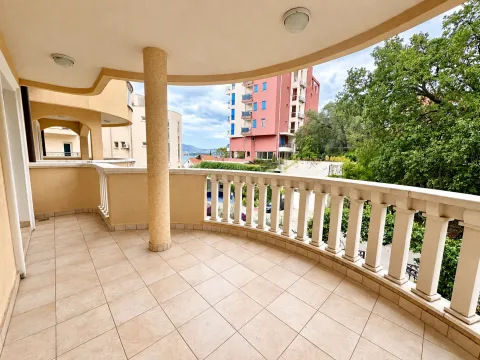 Spacious covered balcony with columns and a view of surrounding buildings and greenery. - image 2
