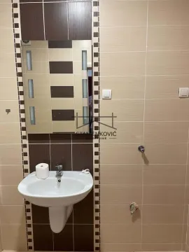 Kupatilo sa umivaonikom i ogledalom obloženo keramičkim pločicama. - image 15