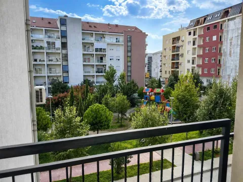 Pogled sa terase na okolne stambene zgrade i uređeno dvorište sa dječijim igralištem. - image 17