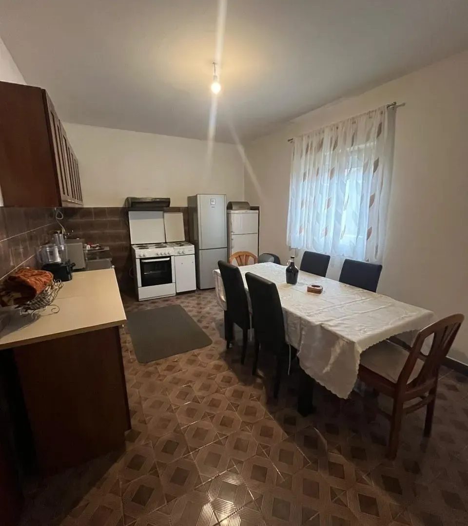 Kuhinja sa trpezarijom i garniturom za sedenje.