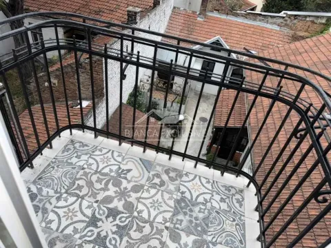 Balkon sa dekorativnim pločicama i pogledom na krovove i dvorište. - image 13