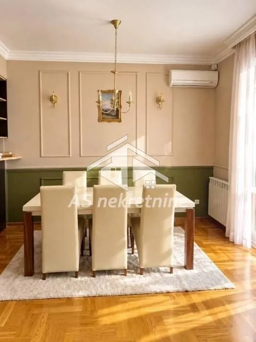 Trpezarija sa stolom i stolicama u svetlim tonovima.