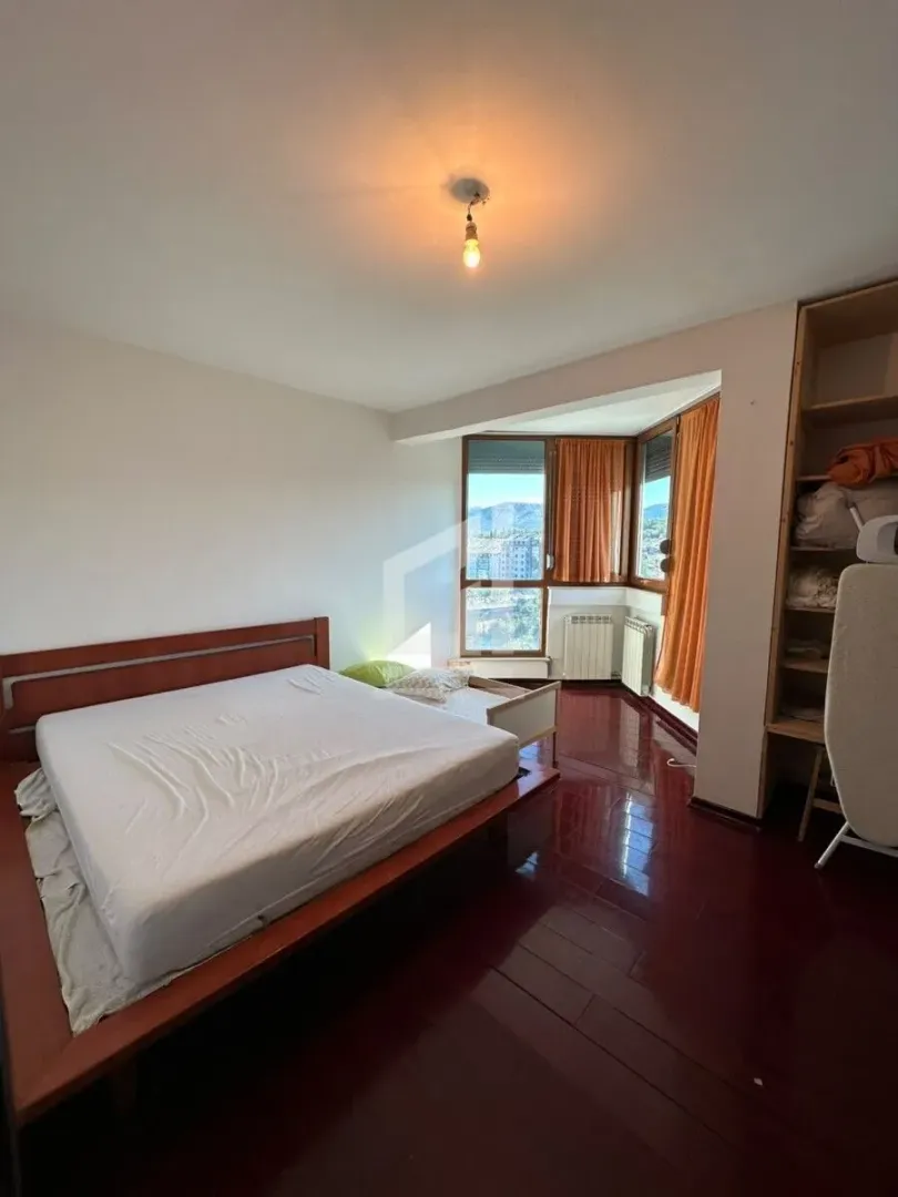 Bedroom with a double bed, wooden flooring and windows with a view.