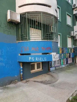 Exterior of a residential building with a terrace and graffiti on the facade. - image 2
