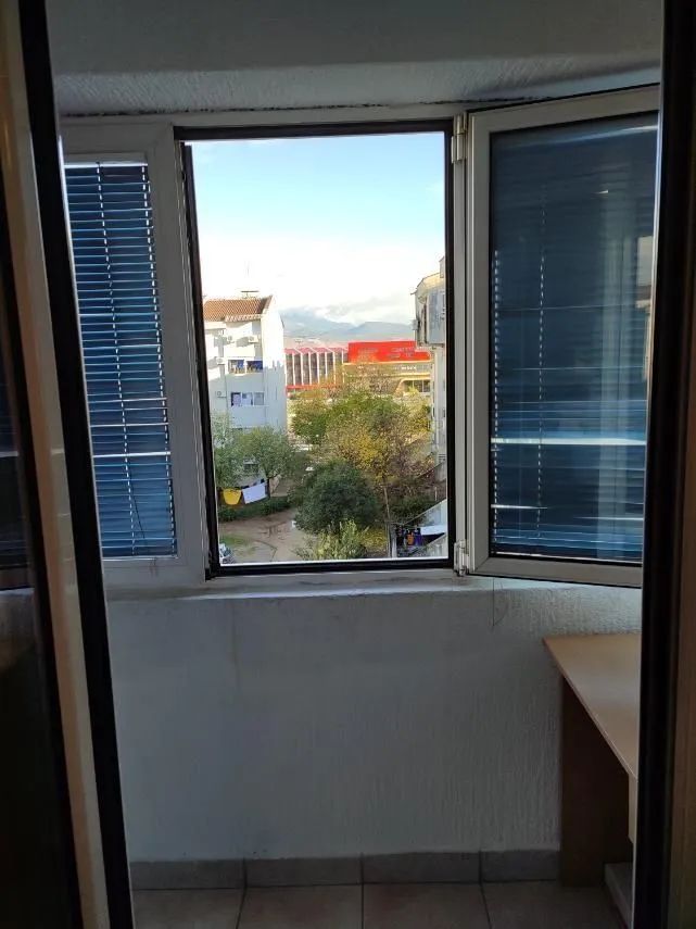 View through a glazed balcony window looking out at the neighborhood.