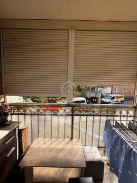 Covered balcony with a table, chairs, and lowered roller blinds. - image 6