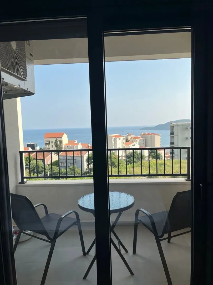 Namješten balkon sa garniturom za sjedenje i pogledom na more.