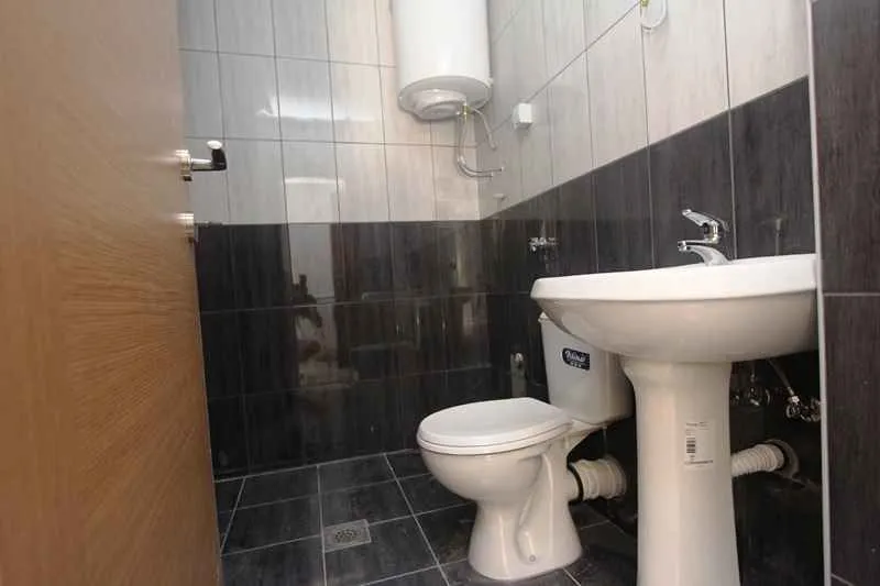 Manje kupatilo sa umivaonikom, WC šoljom i bojlerom.